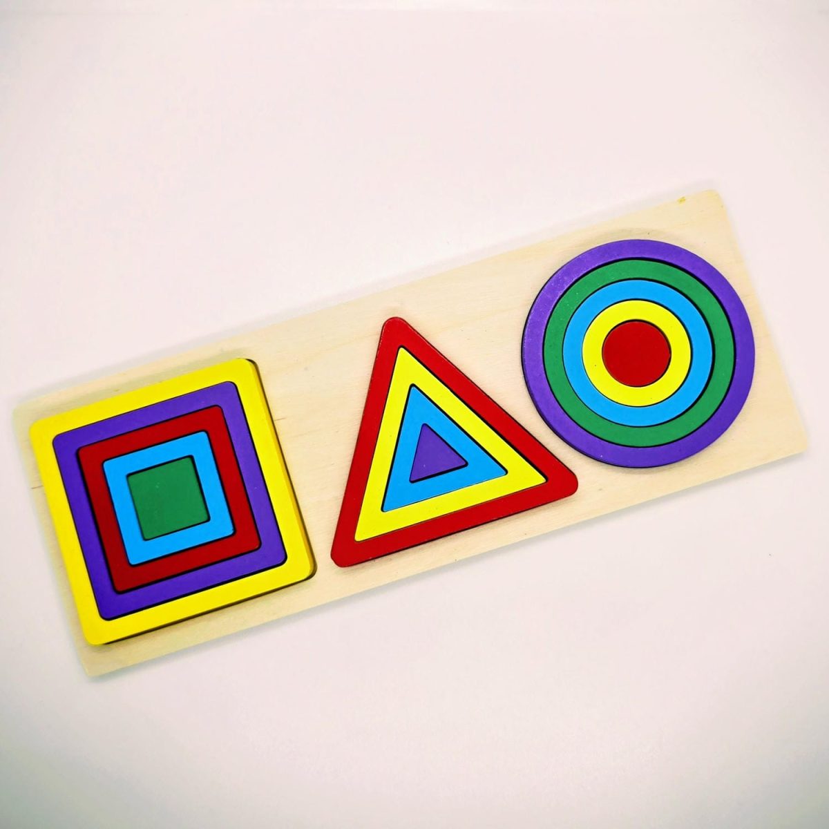 Triplet Geometric Shapes Puzzle with colorful wooden circles, triangles, and squares on a wooden board